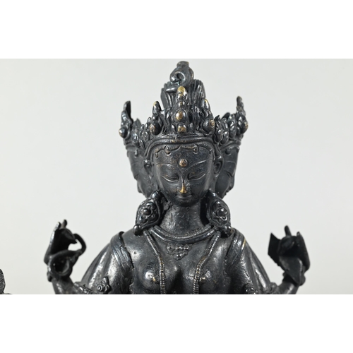 443 - A Nepalese bronze figure of the three-faced Buddhist goddess Vasudhara, seated in royal ease positio... 