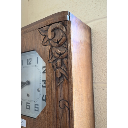 129 - A German Art Deco oak wall clock with octagonal silvered dial, striking and chiming on gongs, 64 cm