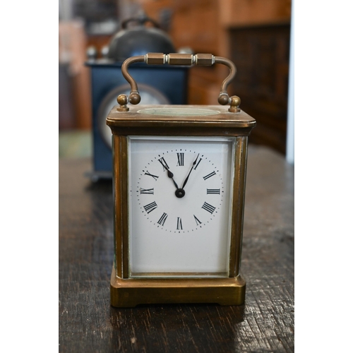 132 - A French brass carriage clock, 15 cm high overall, to/w an American painted tin alarm clock (2)