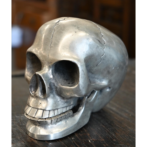 186 - A pewter skull with articulated jaw, 19 cm high