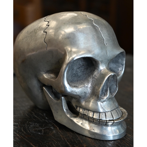 186 - A pewter skull with articulated jaw, 19 cm high