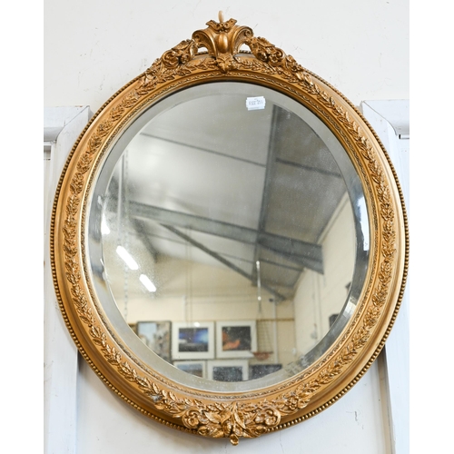 223 - A pair of bevelled oval wall mirrors in foliate gilt frames, 44 cm wide x 54 cm high