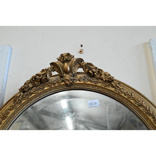 223 - A pair of bevelled oval wall mirrors in foliate gilt frames, 44 cm wide x 54 cm high