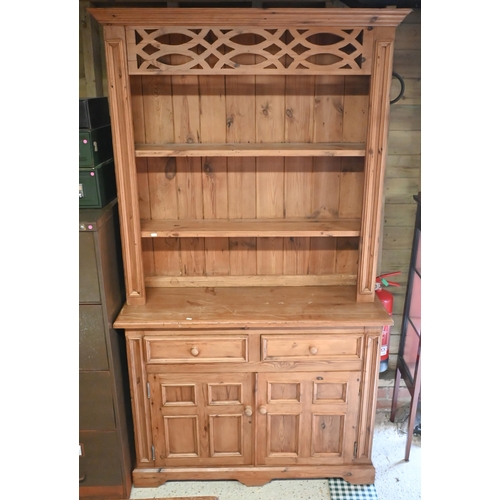 551 - A waxed pine dresser with plate rack on a base with two drawers and quad-panelled doors, 118 cm wide... 