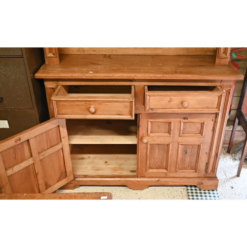 551 - A waxed pine dresser with plate rack on a base with two drawers and quad-panelled doors, 118 cm wide... 