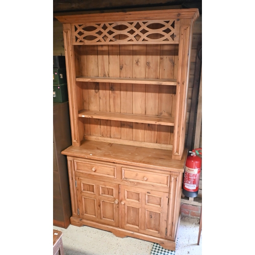 551 - A waxed pine dresser with plate rack on a base with two drawers and quad-panelled doors, 118 cm wide... 