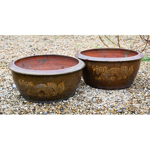 41 - A pair of Chinese style circular salt glazed 'dragon' planters, 44 cm diam x 20 cm high to/w weather... 