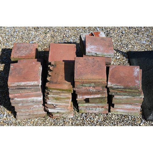 49 - A quantity of old terracotta square tiles, 23 x 23 cm and nineteen crenalated edging tiles