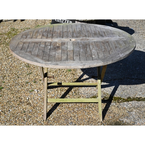 8 - A weathered teak circular garden dining table on folding frame, 120 cm diam x 72 cm high