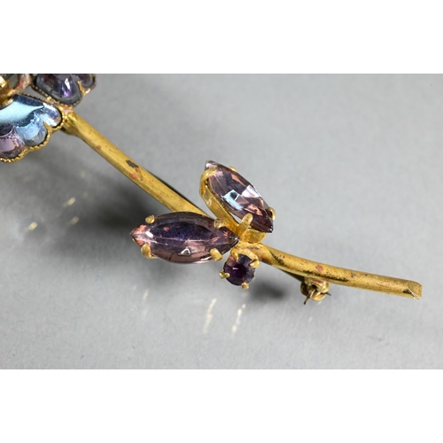 306 - A vintage paste-set brooch in the form of a flower with long stem and leaf decoration, the coloured ... 