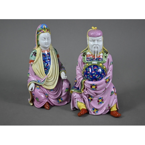 565 - A pair of Dresden figures of a Chinese couple in pink official's robes painted with flowers and bird... 