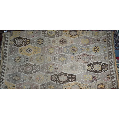 818 - An old Turkish kelim, the soft multi-coloured lozenge design on camel ground, 290 cm x 154 cm