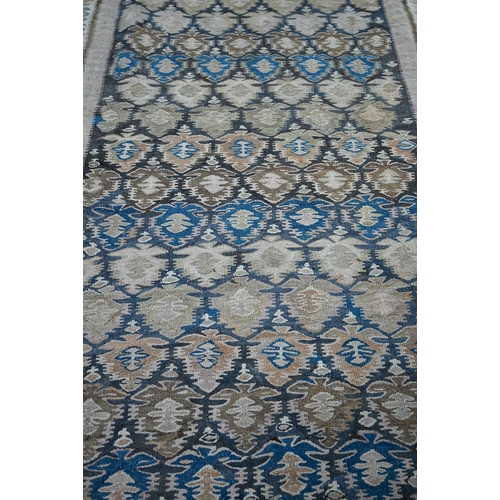 819 - A large old Caucasian kelim, the interlinked design in muted tones on camel ground, 418 cm x 142 cm