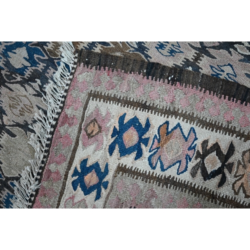 819 - A large old Caucasian kelim, the interlinked design in muted tones on camel ground, 418 cm x 142 cm