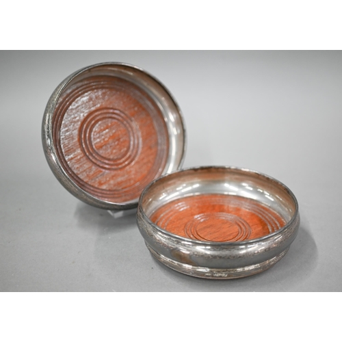 110 - A pair of silver bottle coasters with turned wood bases, Birmingham 1979, to/w a pair of loaded silv... 