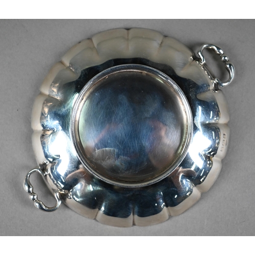 115 - A circular silver small dish with twin loop handles and moulded foot-rim, Adie Brothers, Birmingham ... 