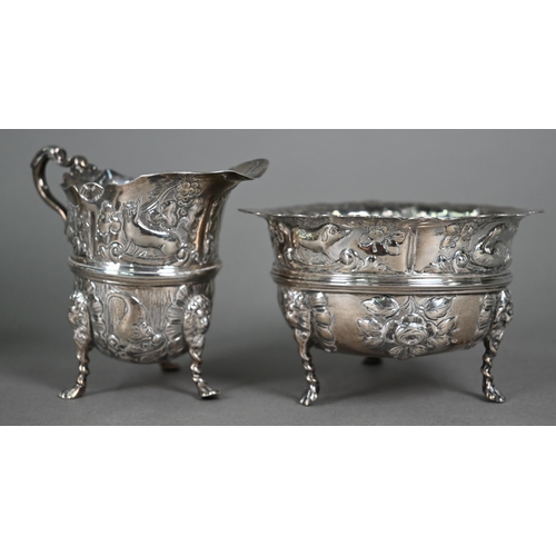 124 - A late Victorian heavy quality silver three-piece tea service, embossed and chased with birds, fish ... 