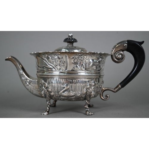 124 - A late Victorian heavy quality silver three-piece tea service, embossed and chased with birds, fish ... 