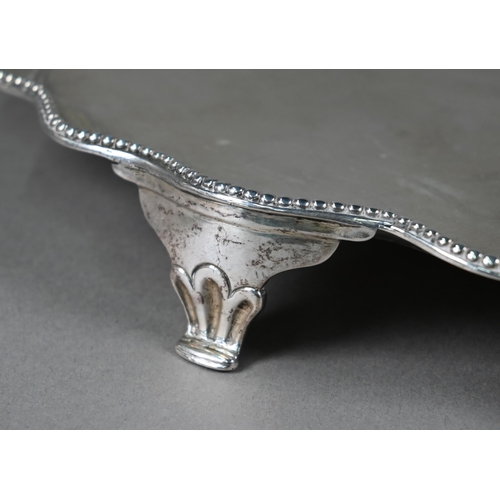 128 - A large George III silver salver with beaded wavy edge, on four bracket feet, engraved with full fam... 