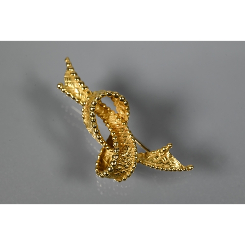 202 - A yellow metal brooch in the form of a loose-knotted ribbon, stamped 750, approx 5.2g 4 cm long