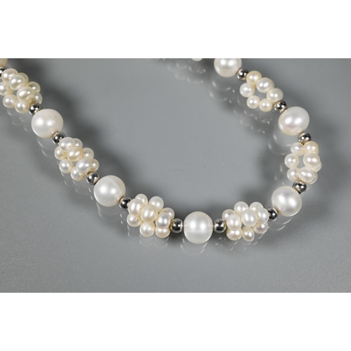 211 - A cultured pearl necklace comprising uniform round cultured pearls alternating with smaller pearl cl... 