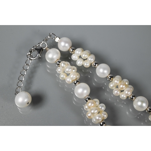 211 - A cultured pearl necklace comprising uniform round cultured pearls alternating with smaller pearl cl... 