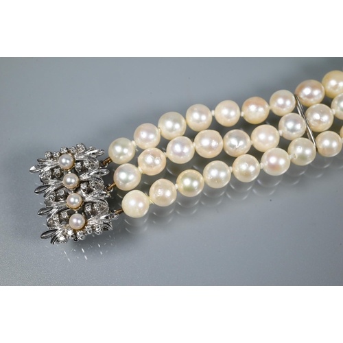 214 - A pearl bracelet, the three-rows of cultured pearls knotted throughout onto fancy white metal set pe... 