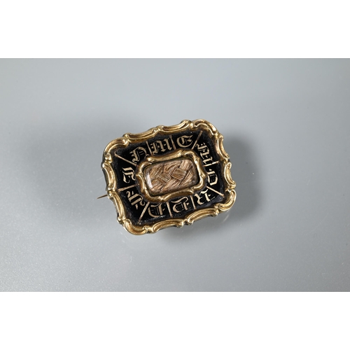 228 - An early Victorian rectangular mourning brooch, the black enamel with inscription around a hairwork ... 