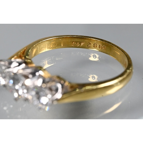 231 - A three-stone diamond ring, the graduated diamonds claw set in platinum, with 18ct yellow gold shank... 