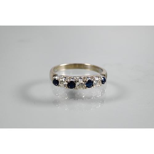 233 - A seven stone ring, the alternate circular dark blue sapphires and diamonds in white metal setting s... 