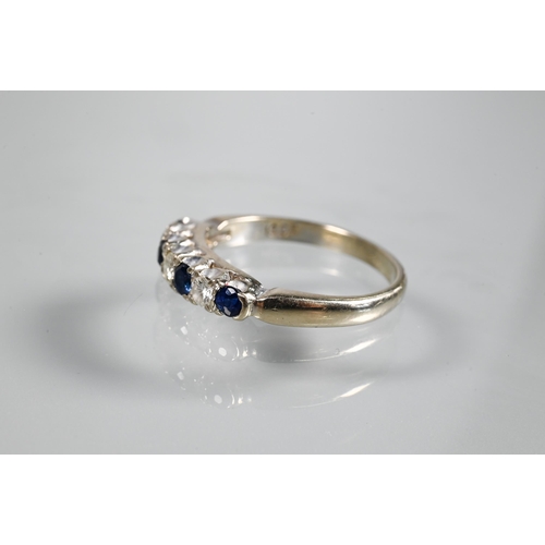 233 - A seven stone ring, the alternate circular dark blue sapphires and diamonds in white metal setting s... 