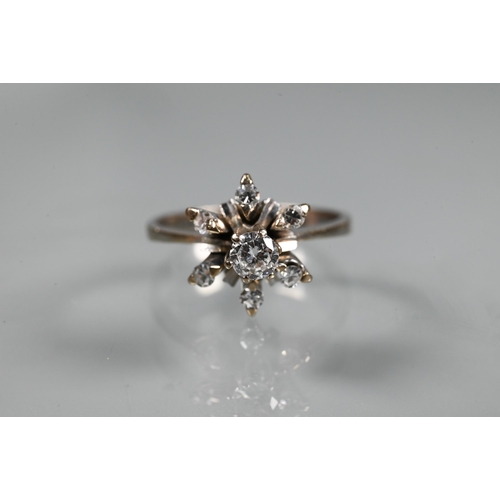 262 - A diamond cluster ring in the form of a star, the central diamond in high claw setting above a starb... 