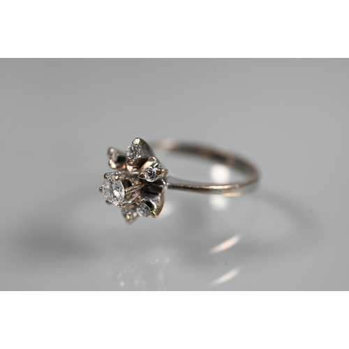 262 - A diamond cluster ring in the form of a star, the central diamond in high claw setting above a starb... 