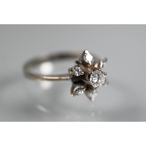 262 - A diamond cluster ring in the form of a star, the central diamond in high claw setting above a starb... 