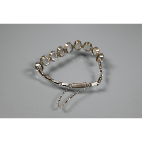 272 - A graduated moonstone and white metal bracelet, 16 cm long