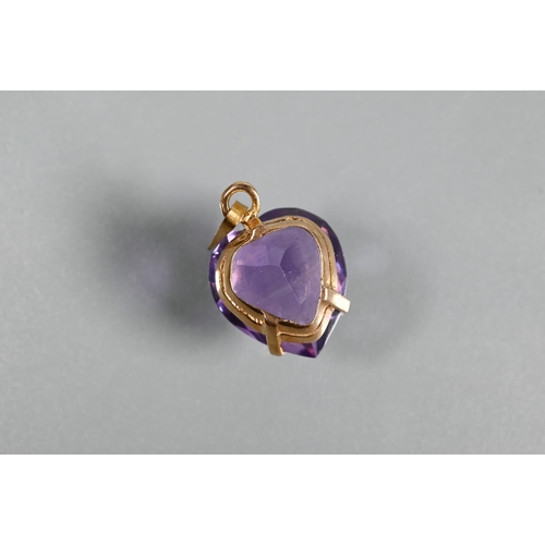 299 - An amethyst pendant in the form of a heart, on yellow metal hanger