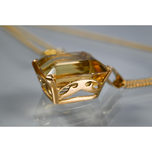 301 - A rectangular baguette-cut yellow topaz pendant on yellow metal chain, the topaz approx 1.3 x 1.1 cm