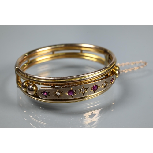 312 - A Victorian 9ct yellow gold oval half-hinged bangle set diamonds and rubies, safety chain attached, ... 