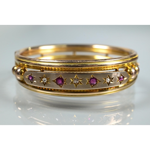 312 - A Victorian 9ct yellow gold oval half-hinged bangle set diamonds and rubies, safety chain attached, ... 