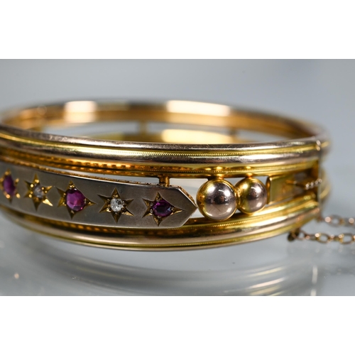 312 - A Victorian 9ct yellow gold oval half-hinged bangle set diamonds and rubies, safety chain attached, ... 