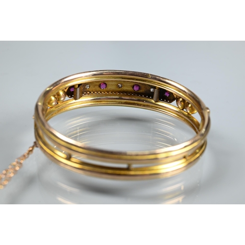 312 - A Victorian 9ct yellow gold oval half-hinged bangle set diamonds and rubies, safety chain attached, ... 