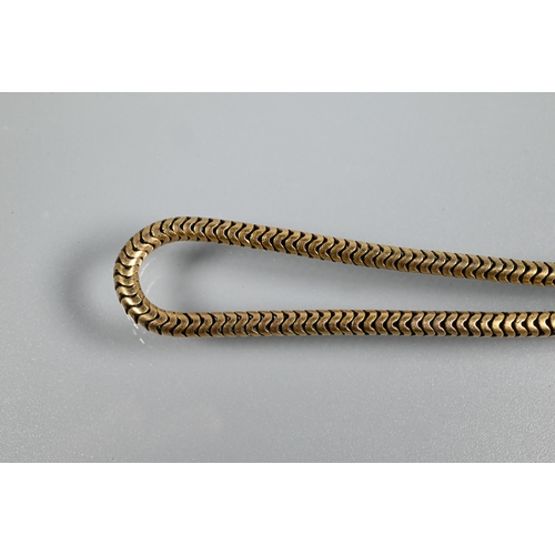 318 - A yellow metal snake-link necklace with engraved cylindrical clasp, unmarked, approx 16g