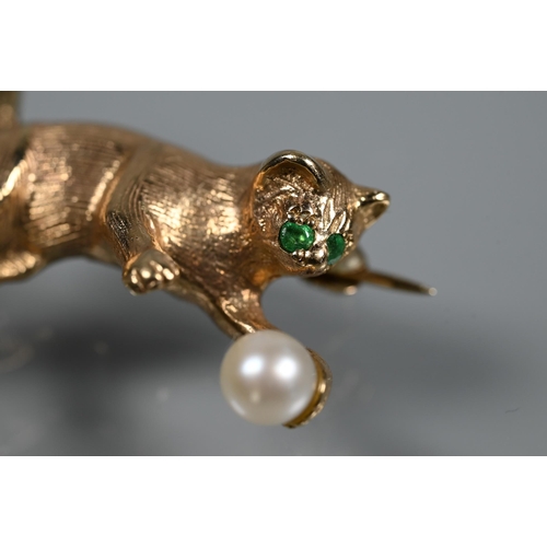 322 - A 9ct yellow gold brooch in the form of a cat playing with a pearl in the form of a ball, with emera... 