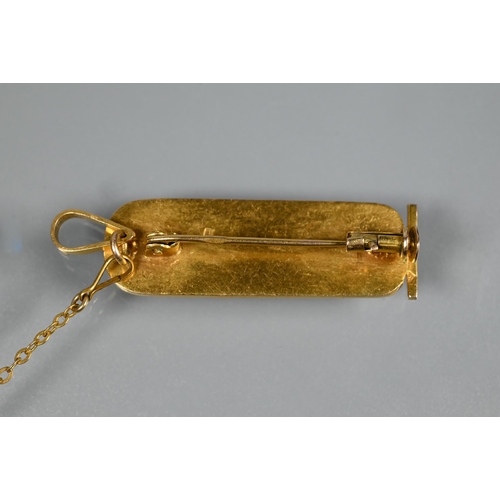 325 - A yellow metal Egyptian cartouche with hieroglyphics in the form of a brooch, safety chain attached,... 