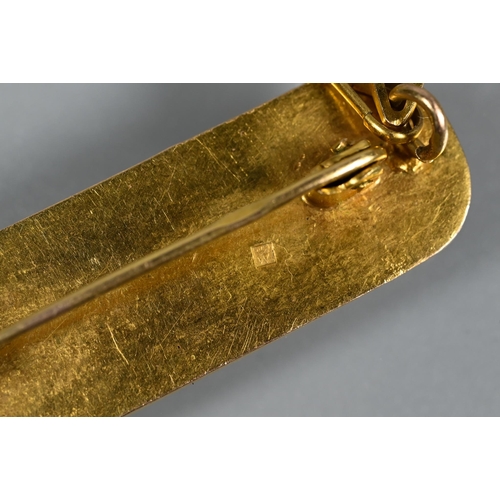 325 - A yellow metal Egyptian cartouche with hieroglyphics in the form of a brooch, safety chain attached,... 