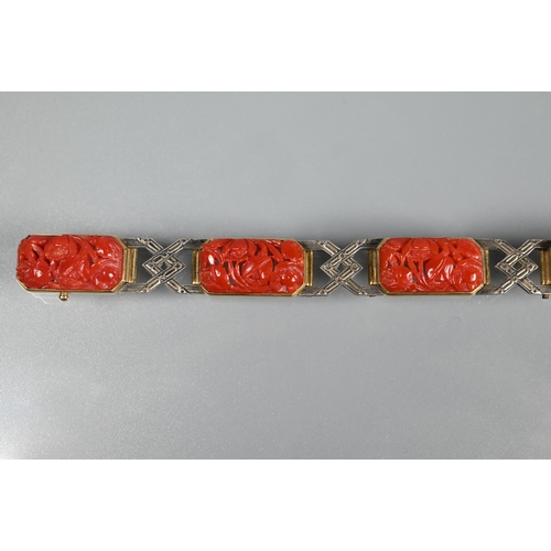 327 - An Art Deco style bracelet formed of carved coral rectangular panels with yellow and white metal geo... 