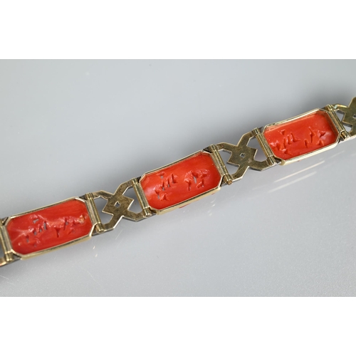 327 - An Art Deco style bracelet formed of carved coral rectangular panels with yellow and white metal geo... 