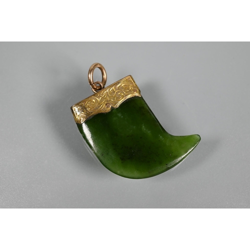 338 - A green nephrite carved tiki, 3 cm long and a green nephrite claw with engraved yellow metal mount t... 