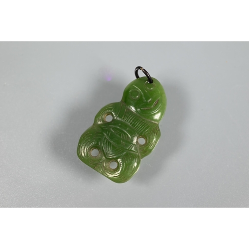 338 - A green nephrite carved tiki, 3 cm long and a green nephrite claw with engraved yellow metal mount t... 