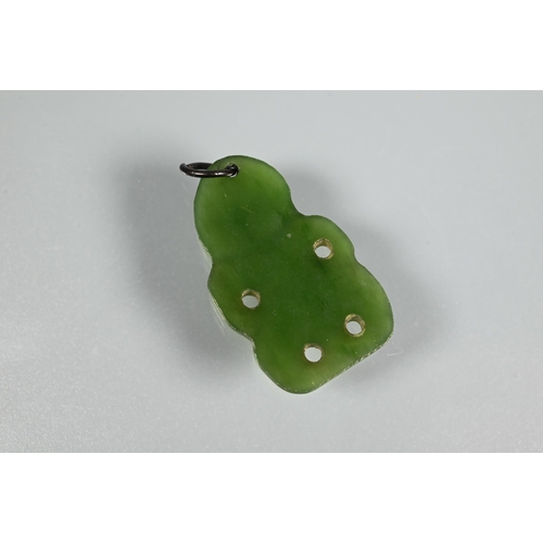 338 - A green nephrite carved tiki, 3 cm long and a green nephrite claw with engraved yellow metal mount t... 